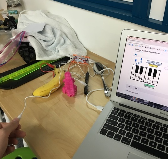 a student creating a makey makey invention with a computer and banana