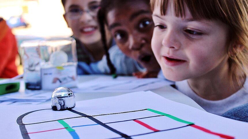 young children working on coding activities with an ozobot robot 