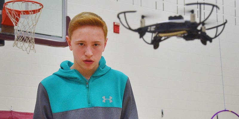 a student flying drone in a school gym