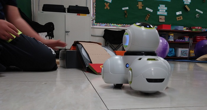 the white cue robot being used with a ramp in an elementary classroom