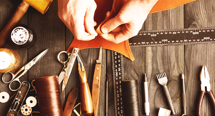 a person's hans spread out on a table full of maker tools