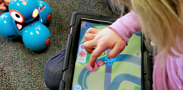 a young child coding with the dash robot