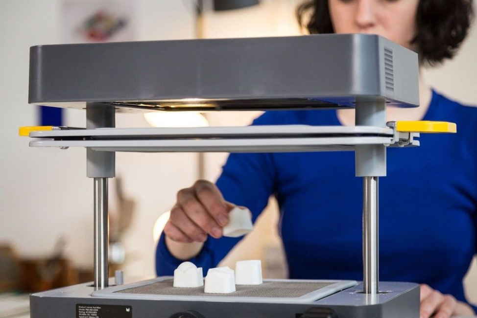 a woman using the mayku formbox vacuum former to create plastic molds