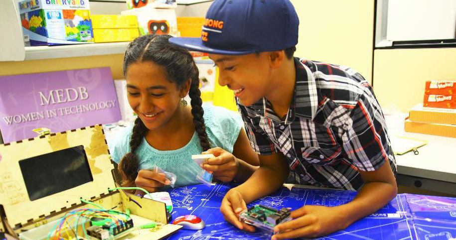 students tinkering with a DIY computer as a result of education leaders scaling STEM programs