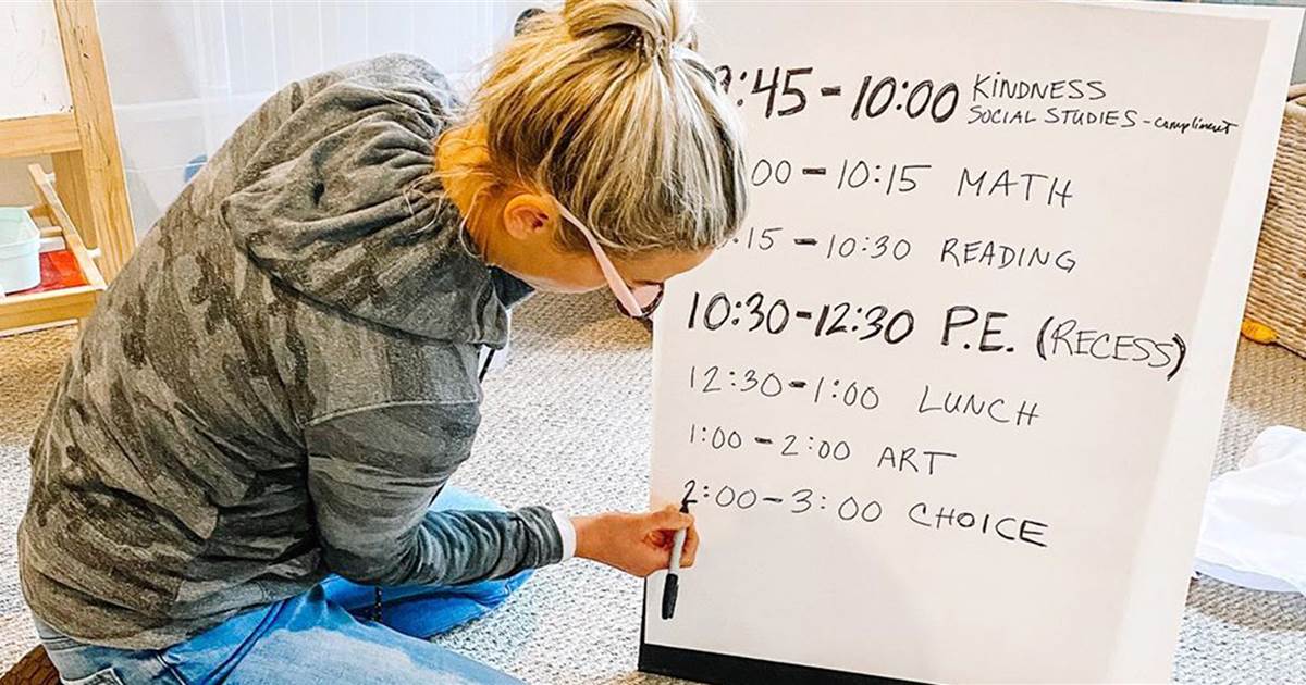 a parent writing out a distance learning schedule to keep kids in a routine during the pandemic