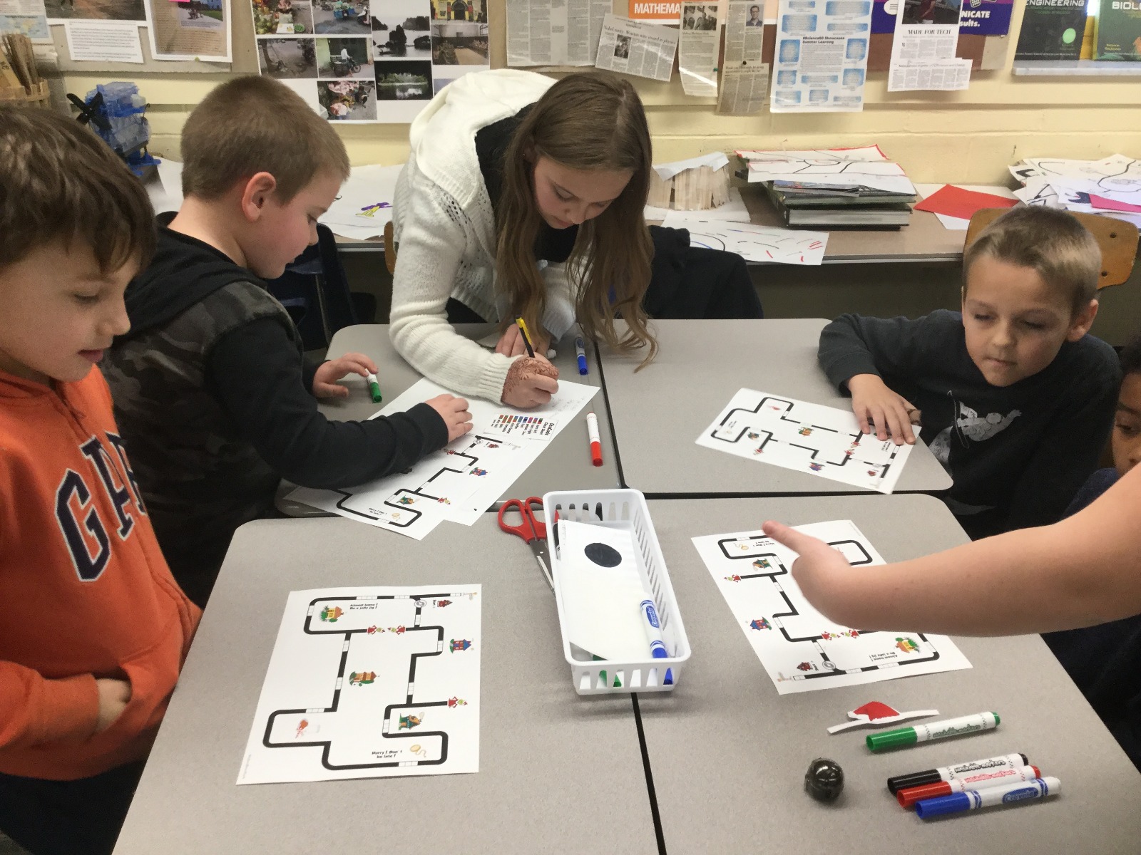young students coding and learning with the ozobot robot with help from a dedicated educator