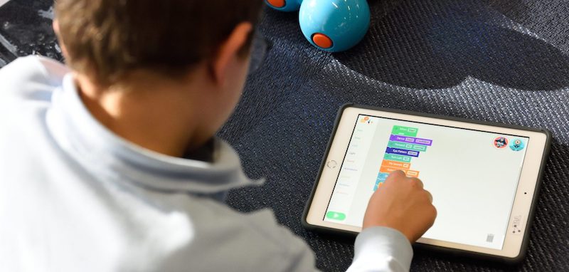 a student exploring block coding with an ipad and the dash robot