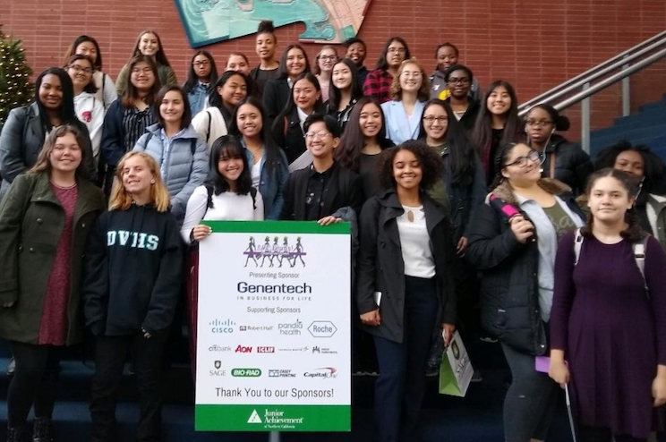 students standing on stairs and holding a banner