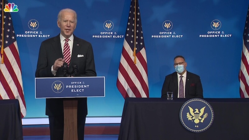 joe biden speaking while education secreaty nominee miguel cardona sits in the background