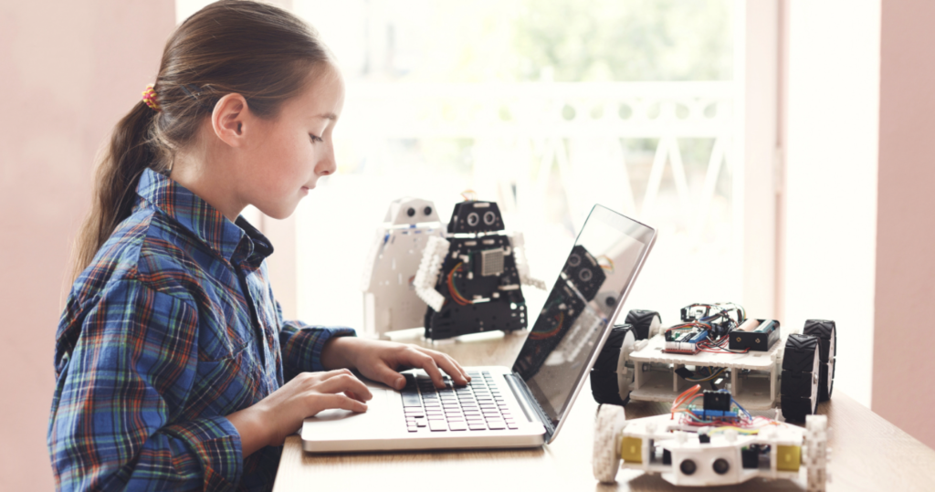 a young girl working with robots and a computer, developing a STEM mindset