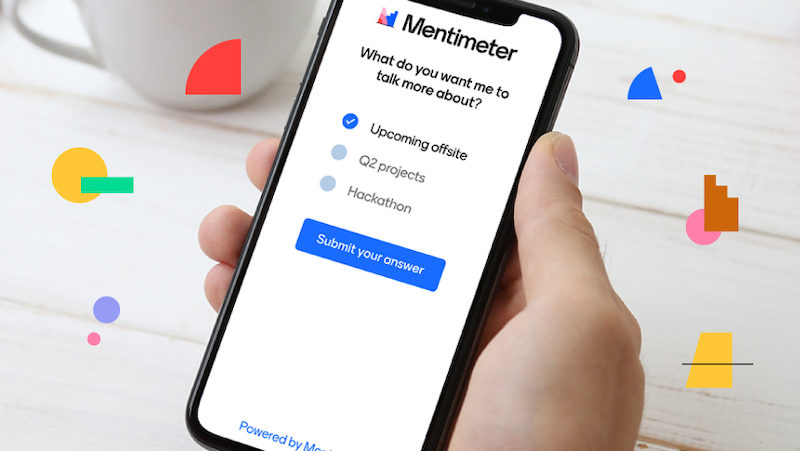 a person holding a smartphone in their hand with the screen displaying the Mentimeter presentation app