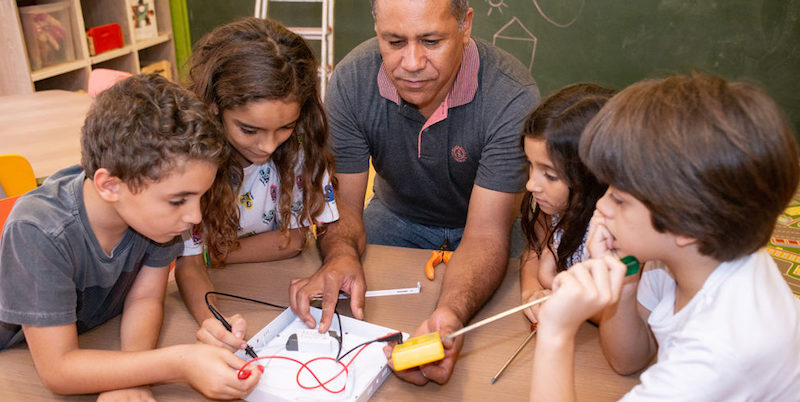 students working with a teacher on a MakerEd project to boost SEL in the classroom