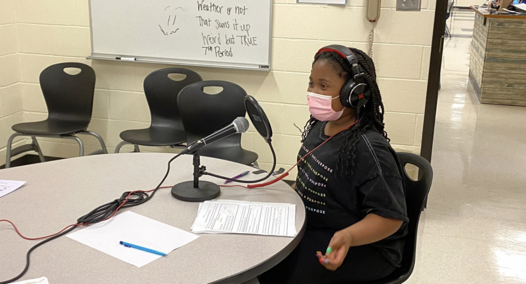 a student speaks into a microphone while working on podcasting in elementary school after learning from experienced educators