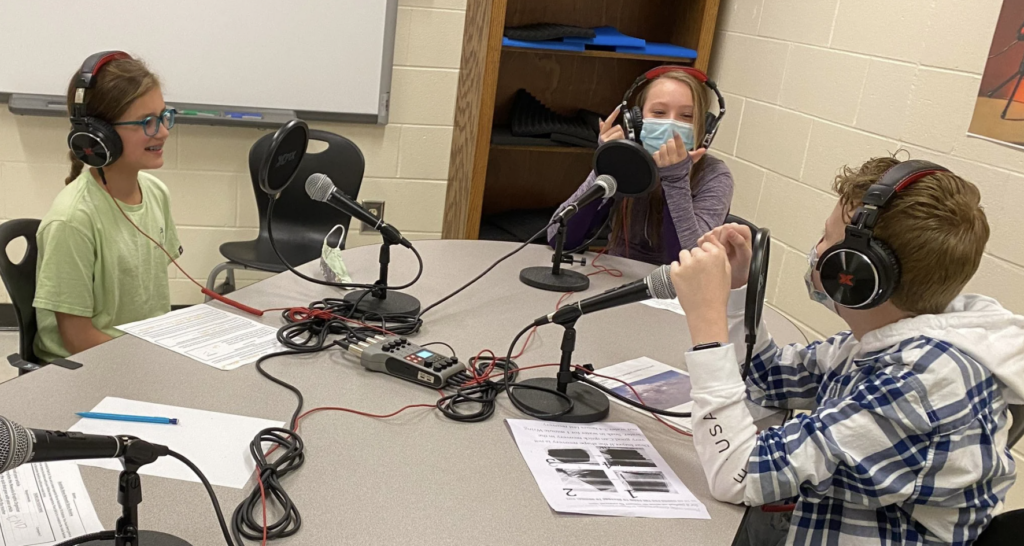 students working together without help from educators on hosting a school podcast
