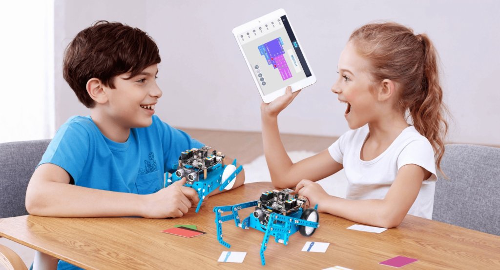 young students work on a STEM project involving programming an mbot robot with a tablet