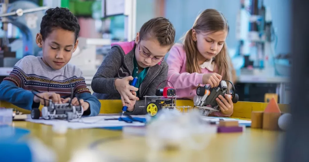 a group of students working on building robots in a school makerspace