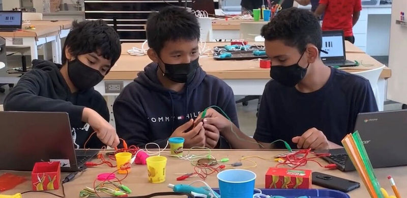 students wearing masks in the classroom and working with STEM education tools