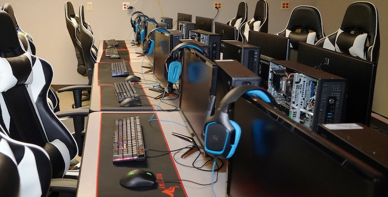 a school esports lab with computers, headphones, and gamin chairs