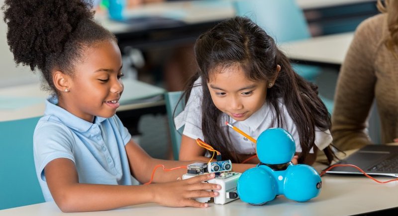 students work with a robot in the classroom as part of a school STEM program