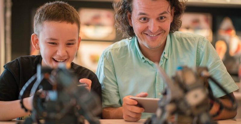 a student and teacher work together to control robots in a STEM class