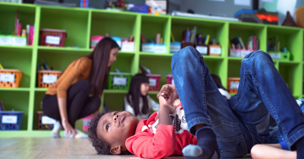 a student laying on the classroom floor and looking discouraged