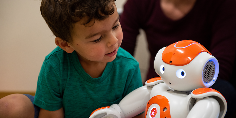 a young student using an educational robot in a special education classroom