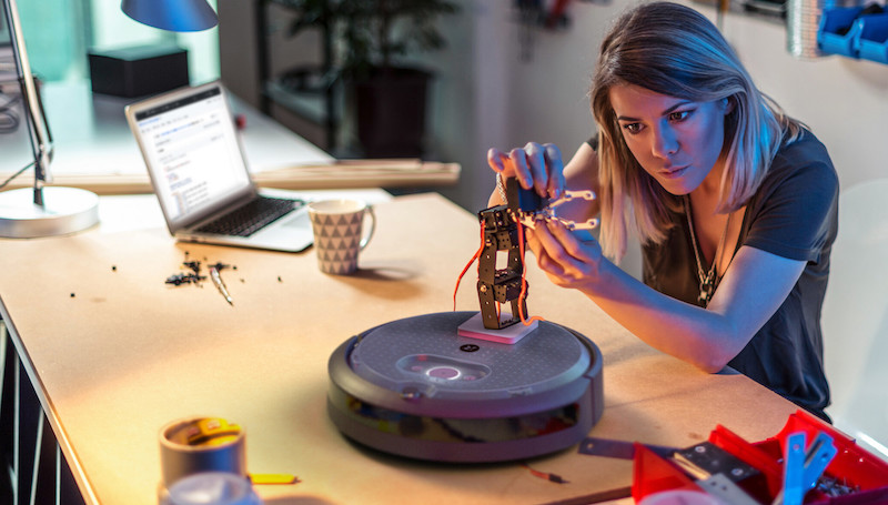 a student using a drill to connect a microcomputer to the irobot create 3