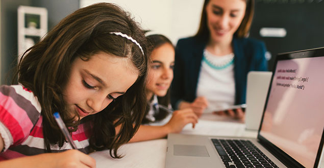 elementary students working on a computer to develop digital literacy skills and writing skills