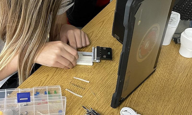 a student practicing programming skills with a breadboard in the classroom