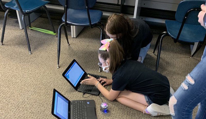 elementary students working on coding skills with sphero coding robots