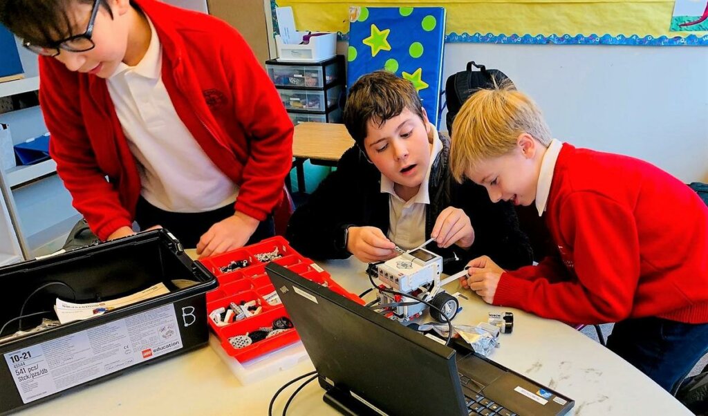 students building a robotic device in an afterschool robotics club