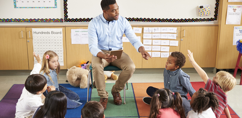 Elementary school kids sitting around teacher in a SEL lesson