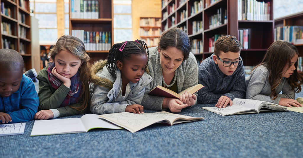 students laying on the ground reading books to promote student voice and choice in how they learn