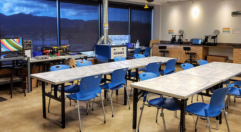 a setup with tables and chairs in a school makerspace