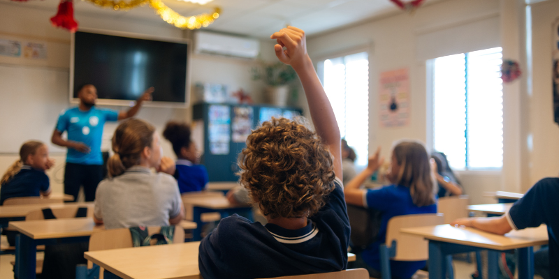 a Student raising his hand in a science classroom