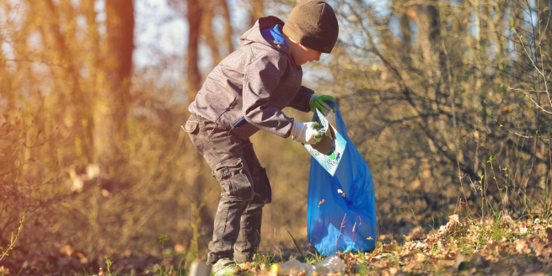 a kid helping pick up litter for earth day