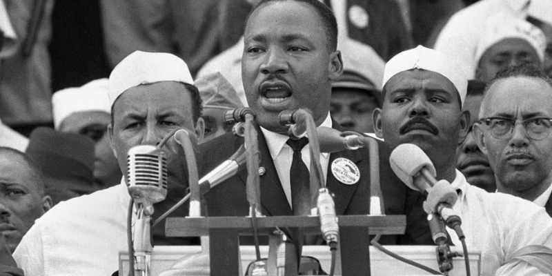 dr. martin luther king jr. reciting a speech at a microphone