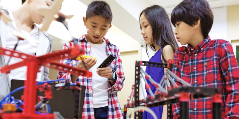 students communicating while using maker tools