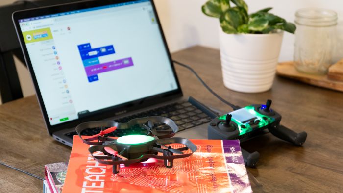 a drone next to a computer that is displaying Blockly code