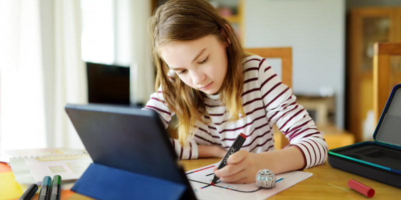 a student drawing a course on paper for the ozobot evo using the ozobot markers