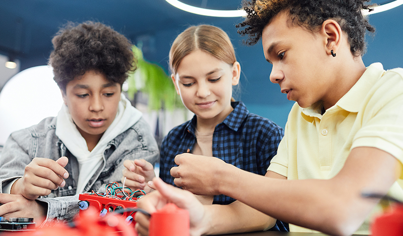 a group of students working on a project involving wires and hardware