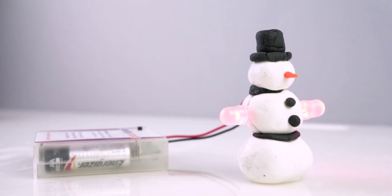 A snowman with LED light arms made out of Squishy Circuits materials