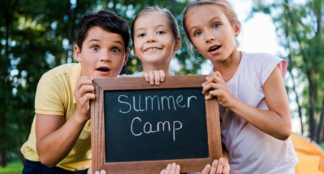 students holding a sign at a summer STEM camp