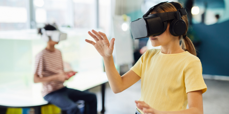 a student using a VR headset in the classroom to explore immersive content